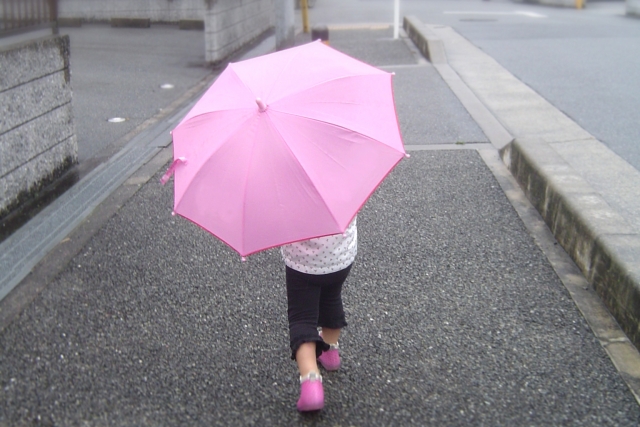 傘をさして歩く子ども